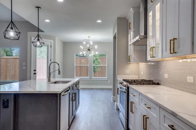 a kitchen with granite countertop a sink stove and cabinets
