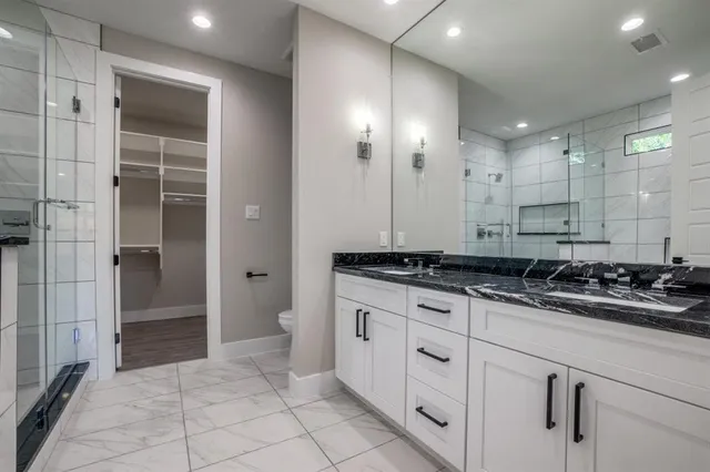 a bathroom with a sink a toilet and shower