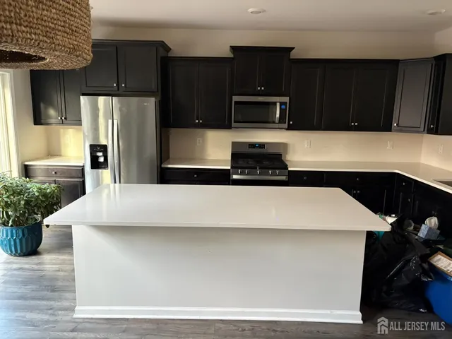 a kitchen with kitchen island white cabinets and refrigerator