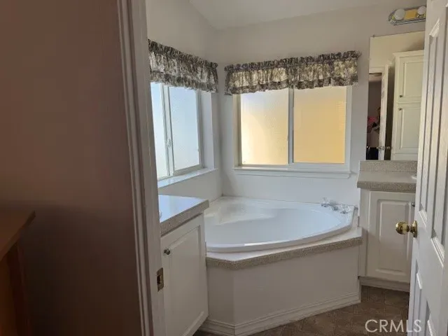 a white bath tub sitting in a bathroom next to a window