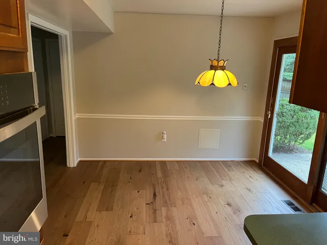 an entryway view with wooden floor and chandelier