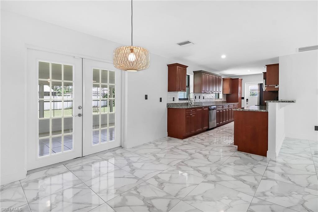 18659 Sarasota Road Fort Myers, FL 33967 - Photo 4 of 19 a large kitchen with stainless steel appliances granite countertop a stove top oven a refrigerator a sink and a large window