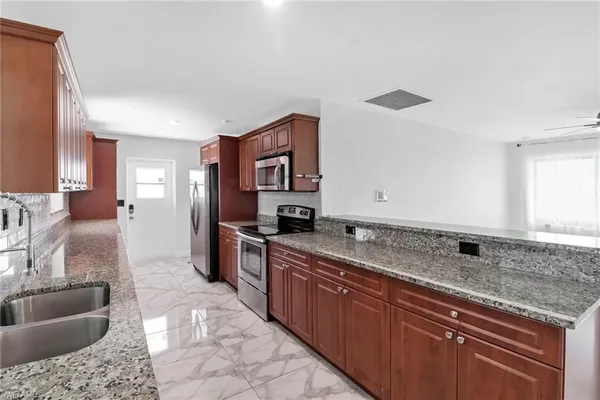 a kitchen with stainless steel appliances granite countertop a sink stove and cabinets