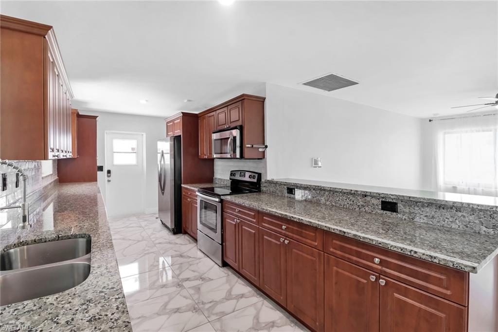 18659 Sarasota Road Fort Myers, FL 33967 - Photo 8 of 19 a kitchen with stainless steel appliances granite countertop a sink stove and cabinets