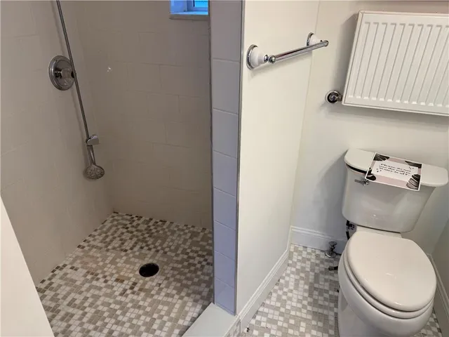 a view of a hallway with wooden floor and a bathroom
