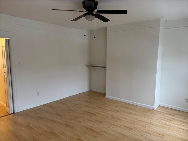 an empty room with wooden floor and closet