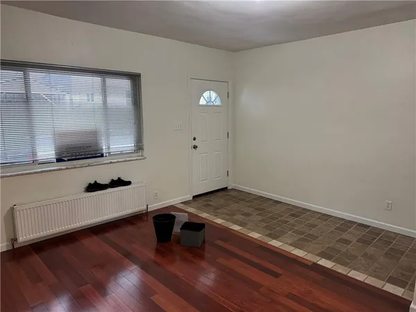 a view of a kitchen with wooden floor and white cabinets
