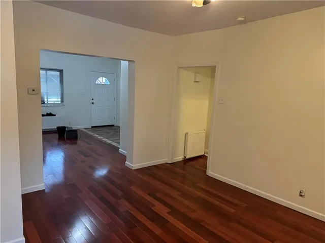 an empty room with wooden floor and closet