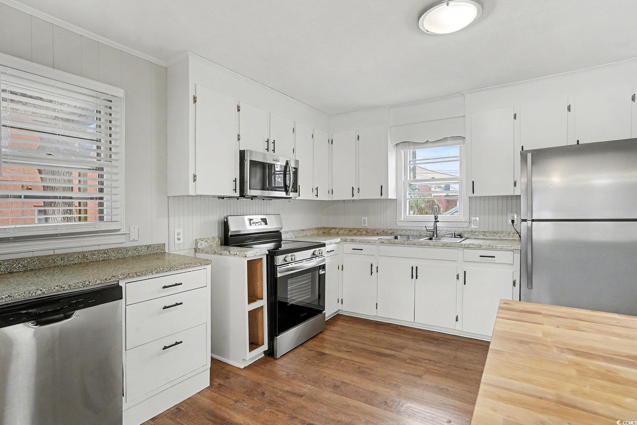 603 Maple Street Myrtle Beach, SC 29577 - Photo 7 of 40 Kitchen featuring appliances with stainless steel finishes, white cabinets, dark wood-style flooring, and butcher block counters