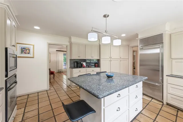 a kitchen with stainless steel appliances granite countertop a sink a refrigerator and a counter top space