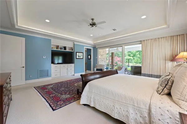 a bedroom with a large bed a flat tv screen and a couch