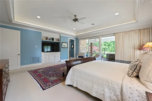 a bedroom with a large bed a flat tv screen and a couch