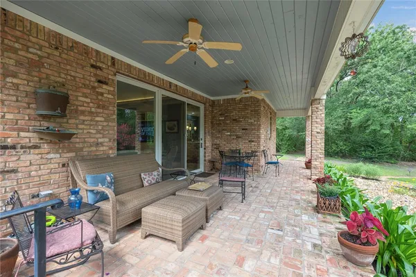 a view of a patio with couches table and chairs and potted plants