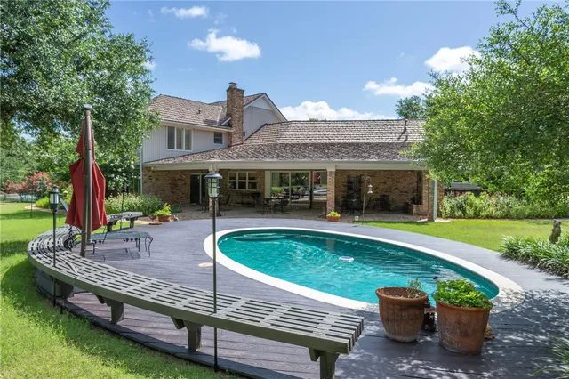 a view of a house with backyard swimming pool and sitting area