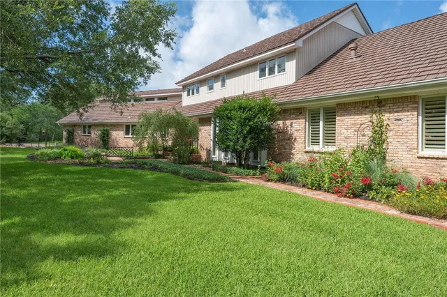 a front view of a residential houses with yard and green space