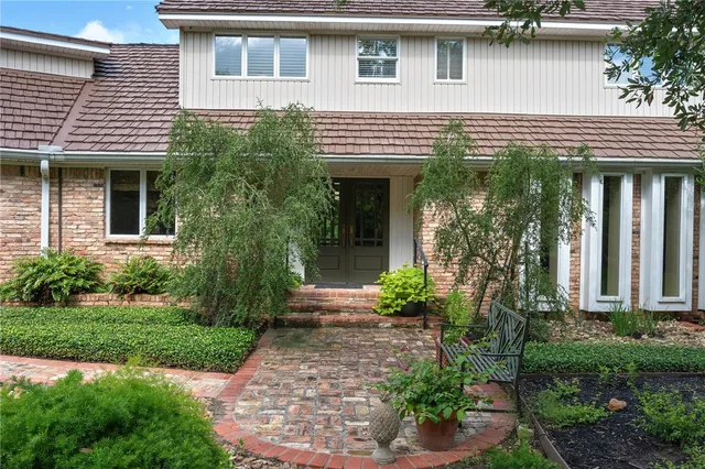 a view of a house with potted plants and a table and chairs