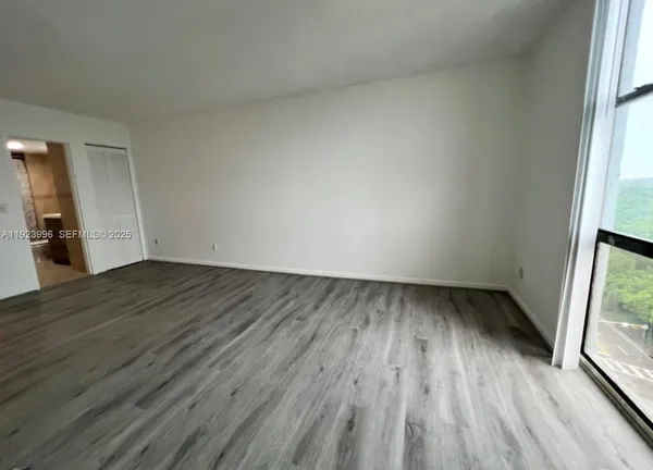 an empty room with wooden floor and a window