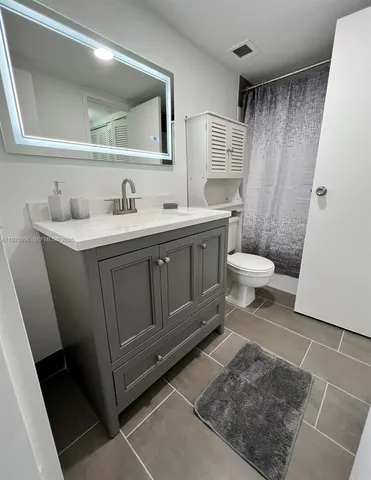 a bathroom with a sink a toilet and a mirror