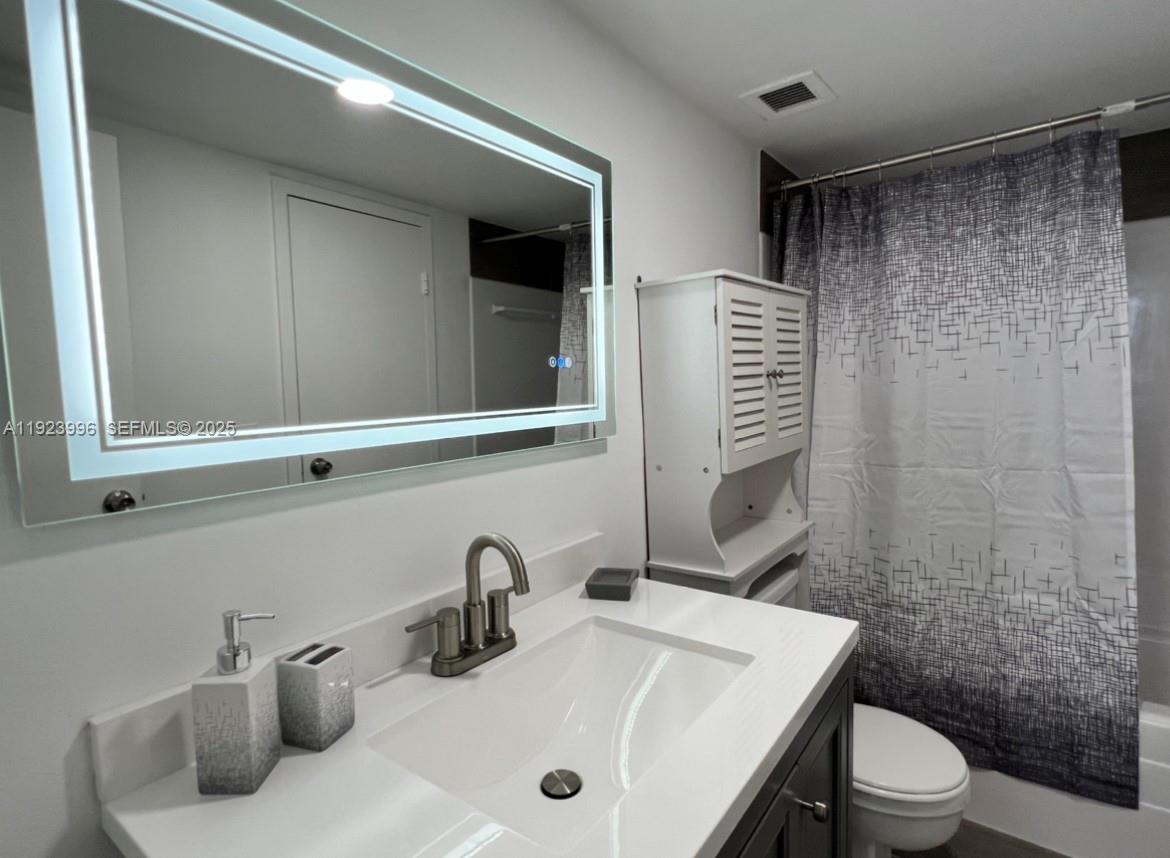 13499 Biscayne Boulevard, Unit 1205 North Miami, FL 33181 - Photo 28 of 32 a bathroom with a sink a toilet and shower