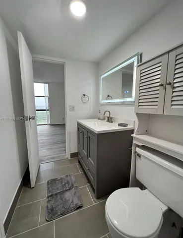 a bathroom with a sink a toilet a mirror and shower