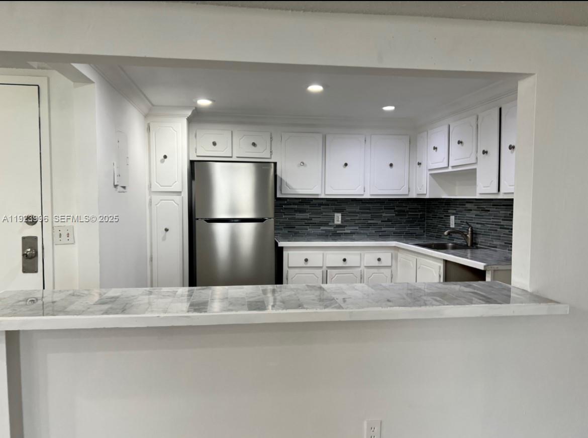13499 Biscayne Boulevard, Unit 1205 North Miami, FL 33181 - Photo 5 of 32 a kitchen with stainless steel appliances granite countertop a refrigerator a sink and white cabinets
