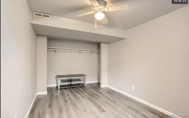 a view of a room with wooden floor and ceiling fan