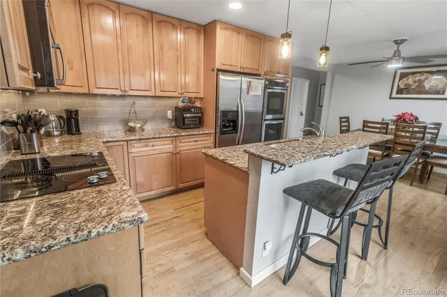 a kitchen with stainless steel appliances granite countertop a stove refrigerator sink and cabinets