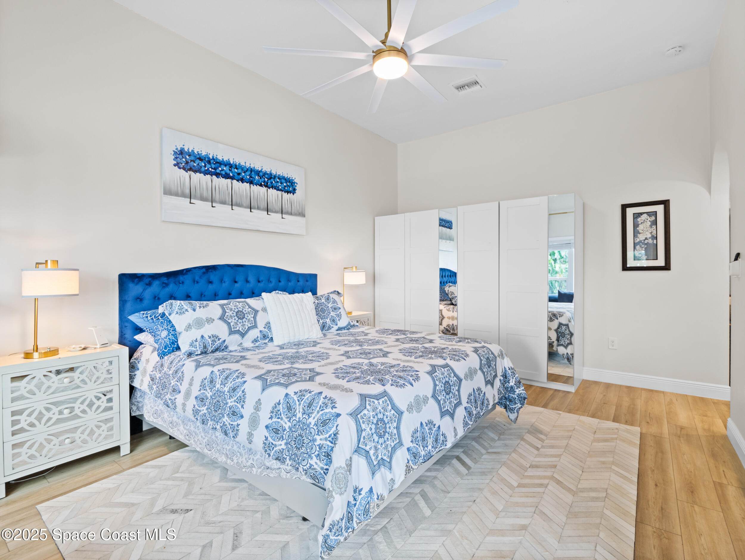 933 South Atlantic Avenue Cocoa Beach, FL 32931 - Photo 26 of 46 a bedroom with a large bed and a chandelier