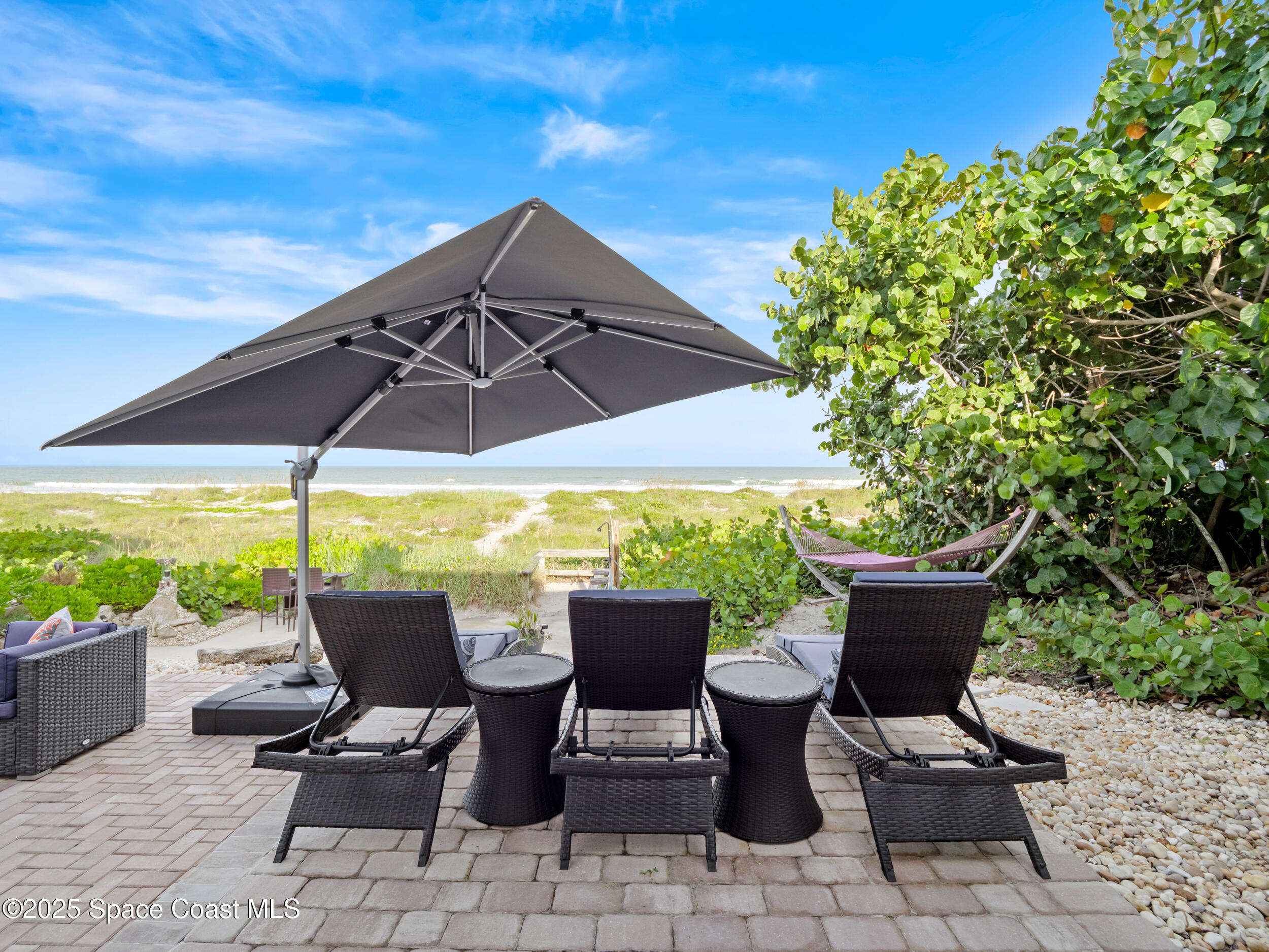 933 South Atlantic Avenue Cocoa Beach, FL 32931 - Photo 10 of 46 a view of an outdoor sitting area with furniture and umbrella