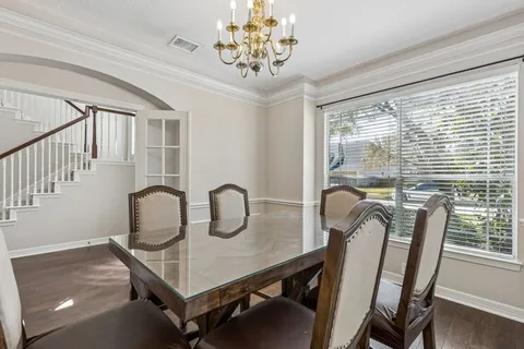 a view of a dining room with furniture a chandelier and wooden floor
