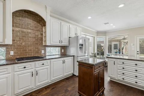 a kitchen with white cabinets and appliances