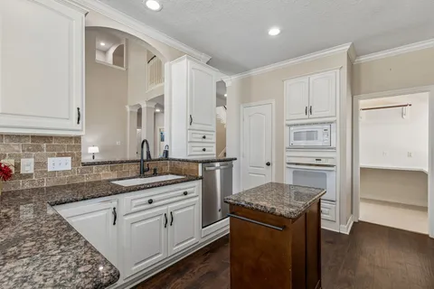 a open kitchen with stainless steel appliances granite countertop a lot of counter space and wooden floors