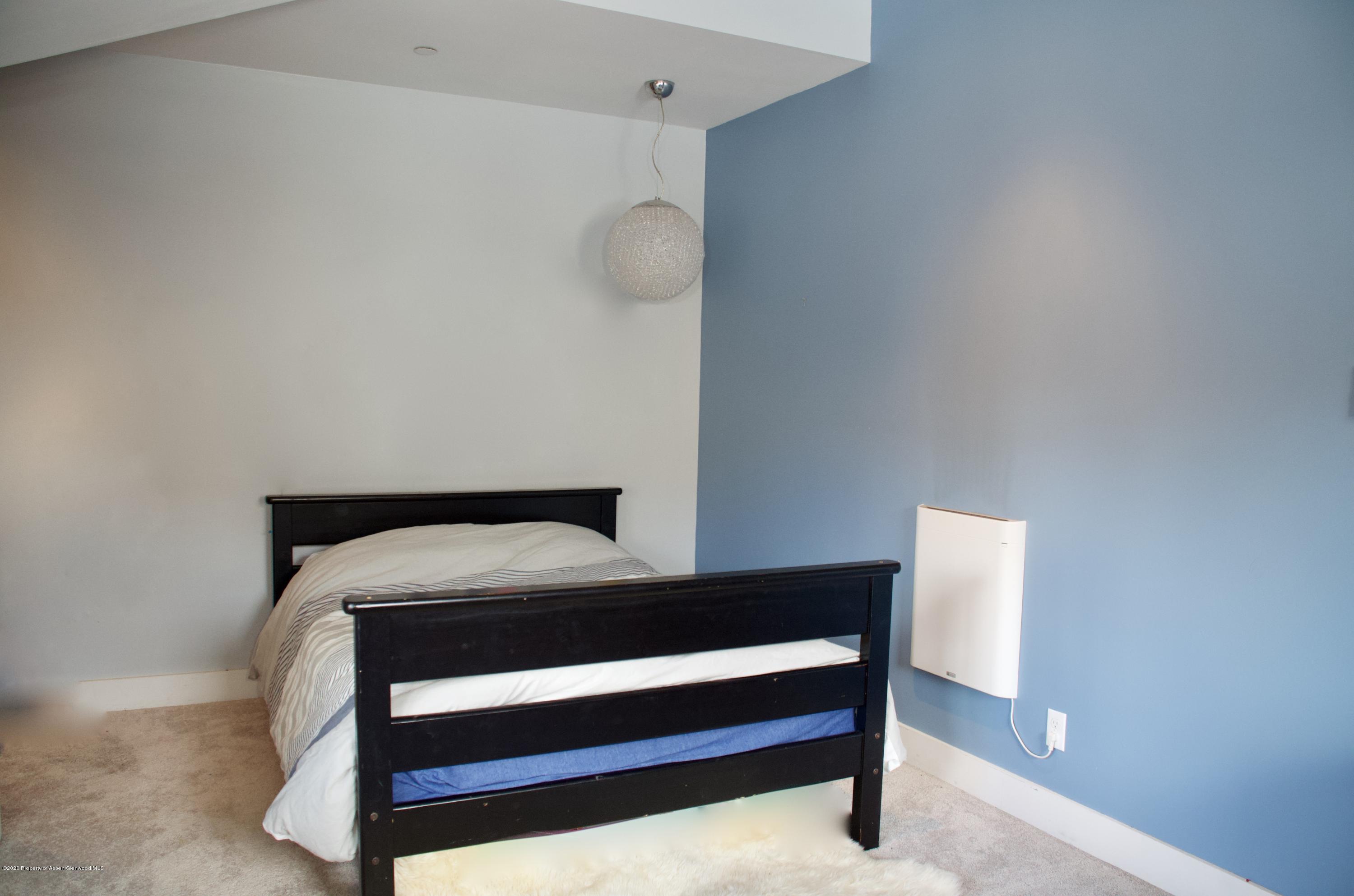 80 Riverdown Drive Aspen, CO 81611 - Photo 26 of 31 a bedroom with a bed and lamp