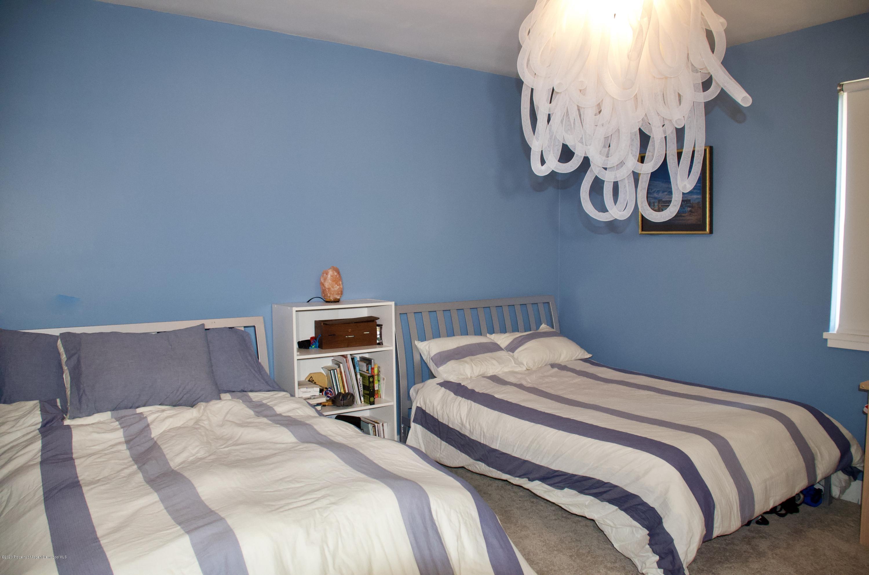 80 Riverdown Drive Aspen, CO 81611 - Photo 27 of 31 a bedroom with a bed and a chandelier