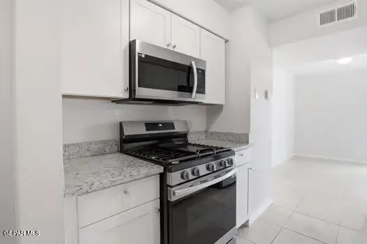 a kitchen with stainless steel appliances granite countertop a stove microwave and sink