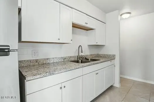 a kitchen with granite countertop a sink and cabinets