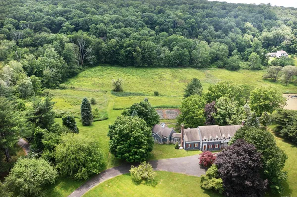 an aerial view of residential house with outdoor space and trees all around