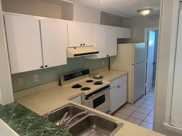 a kitchen with stainless steel appliances a stove a refrigerator and a cabinets