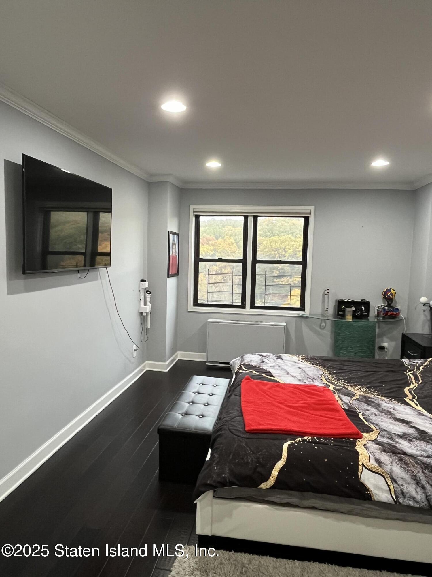 1000 Clove Road, Unit 6O & 6P Staten Island, NY 10301 - Photo 21 of 45 a room with a bed and a flat screen tv