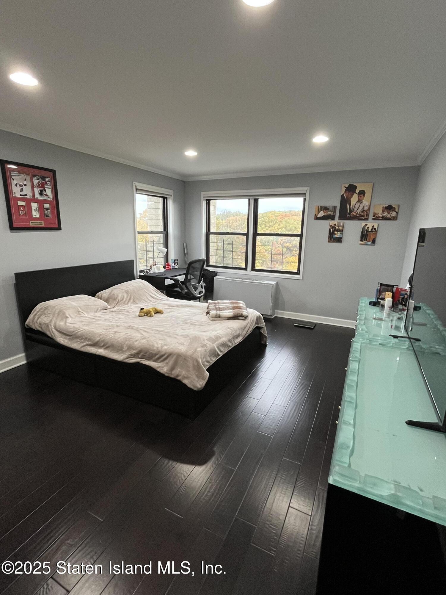 1000 Clove Road, Unit 6O & 6P Staten Island, NY 10301 - Photo 24 of 45 a bed sitting in a bedroom next to a window