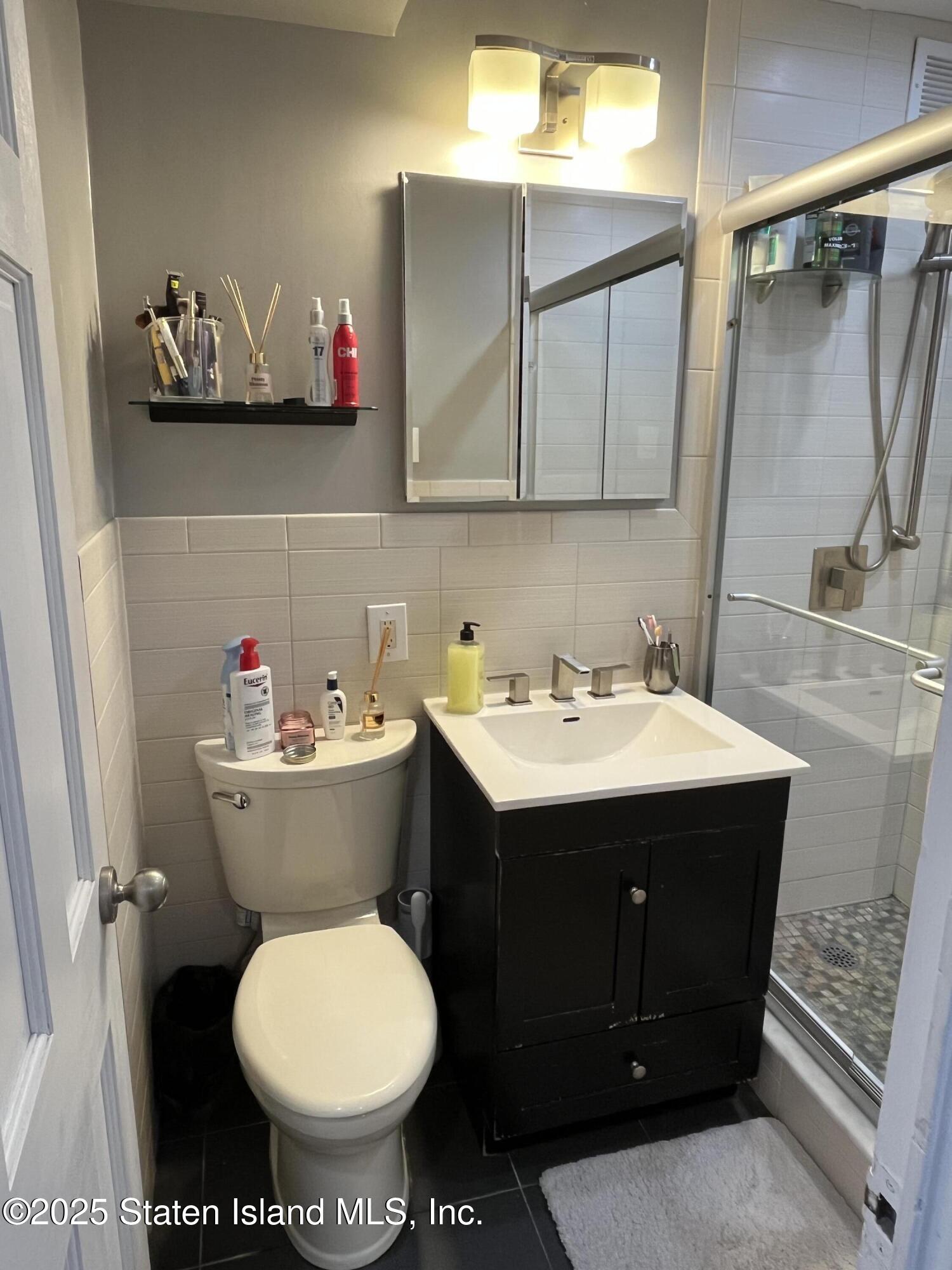 1000 Clove Road, Unit 6O & 6P Staten Island, NY 10301 - Photo 26 of 45 a bathroom with a sink toilet and mirror