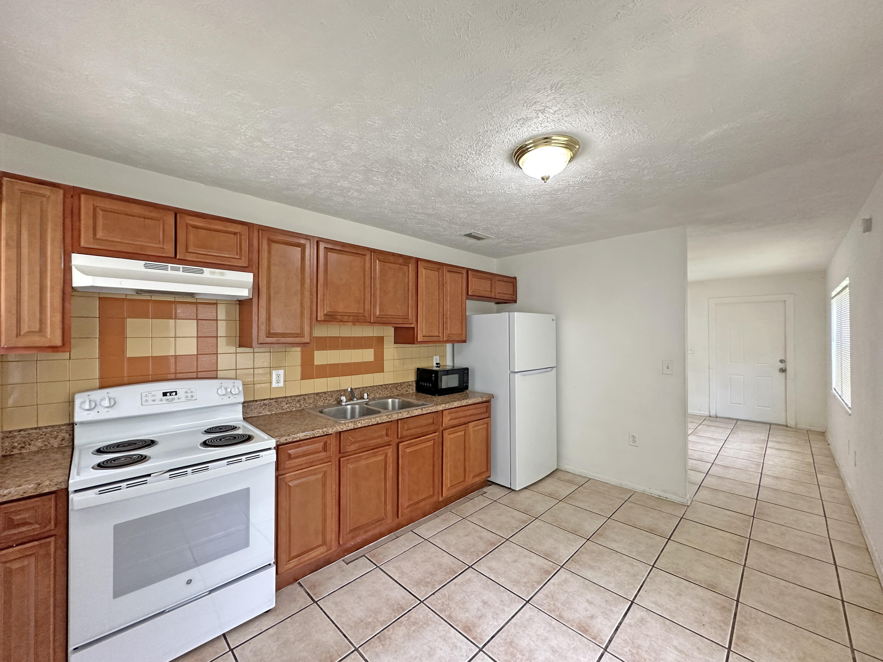 1107 North 21st Street, Unit A & B Fort Pierce, FL 34950 - Photo 18 of 24 a kitchen with a stove a sink and a refrigerator