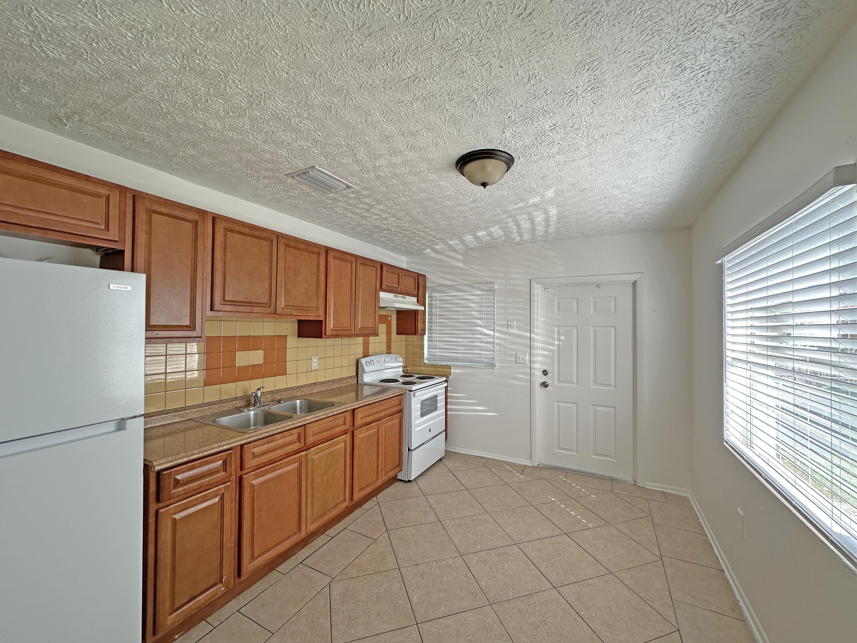 1107 North 21st Street, Unit A & B Fort Pierce, FL 34950 - Photo 10 of 24 a kitchen with a refrigerator sink and cabinets