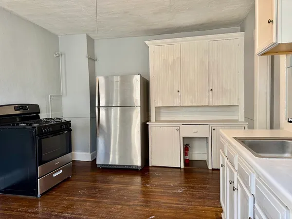 a kitchen with a refrigerator stove and white cabinets