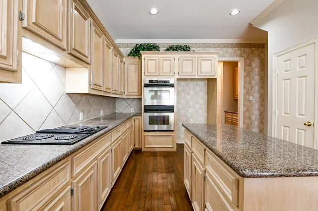 a kitchen with stainless steel appliances granite countertop a refrigerator a stove and a sink