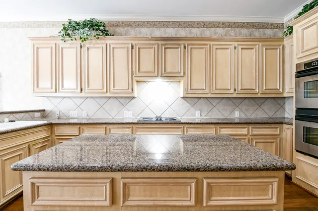 a kitchen with granite countertop a sink a window and cabinets