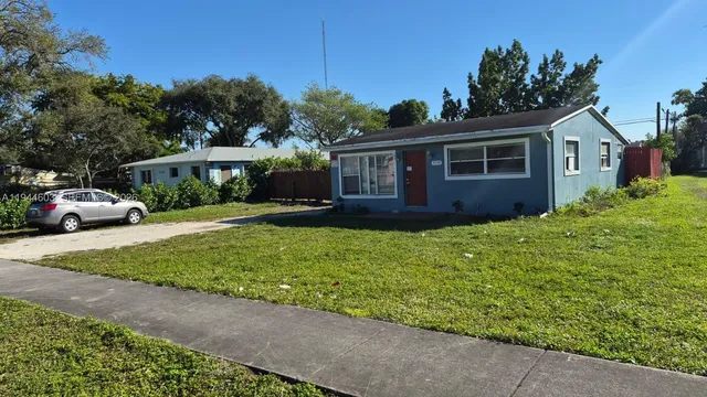 a front view of a house with a garden and trees