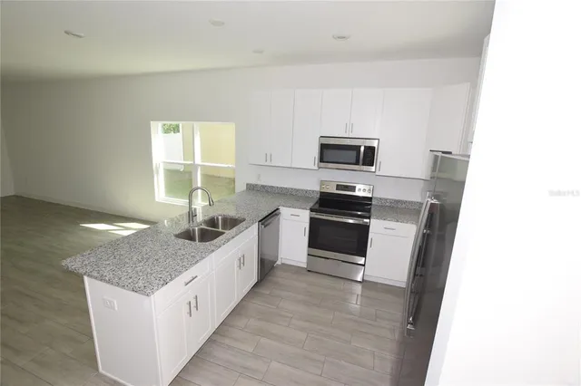 a kitchen with granite countertop a sink and a stove top oven