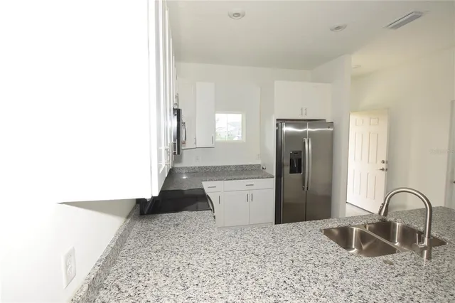a kitchen with a refrigerator and a sink