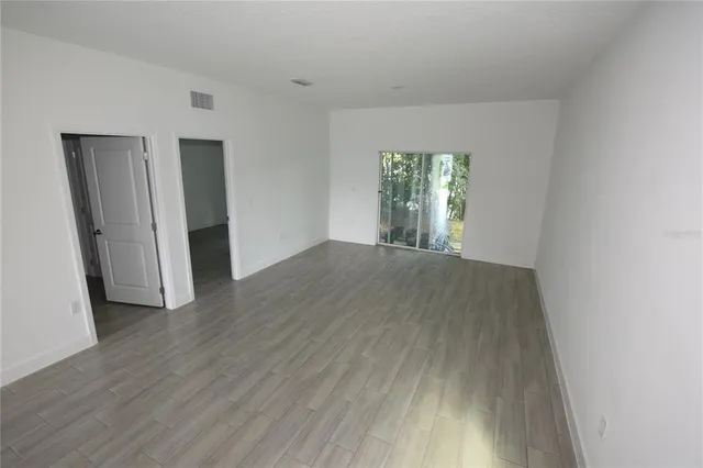 an empty room with wooden floor and a window
